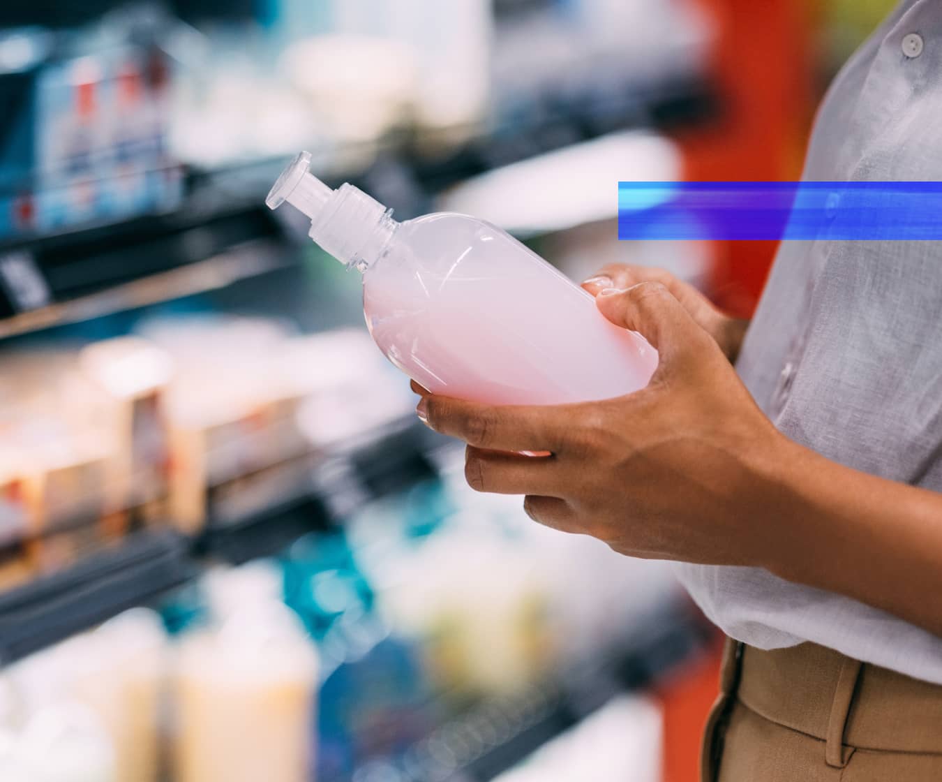 A shopper examines a consumer product on a retail shelf.
