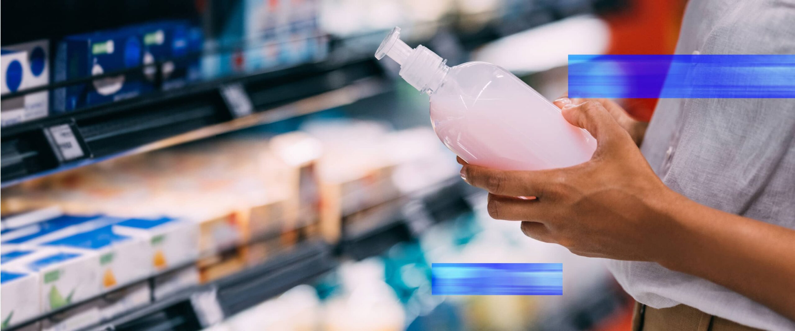 Consumer inspecting a packaged bottle while shopping in a retail store.