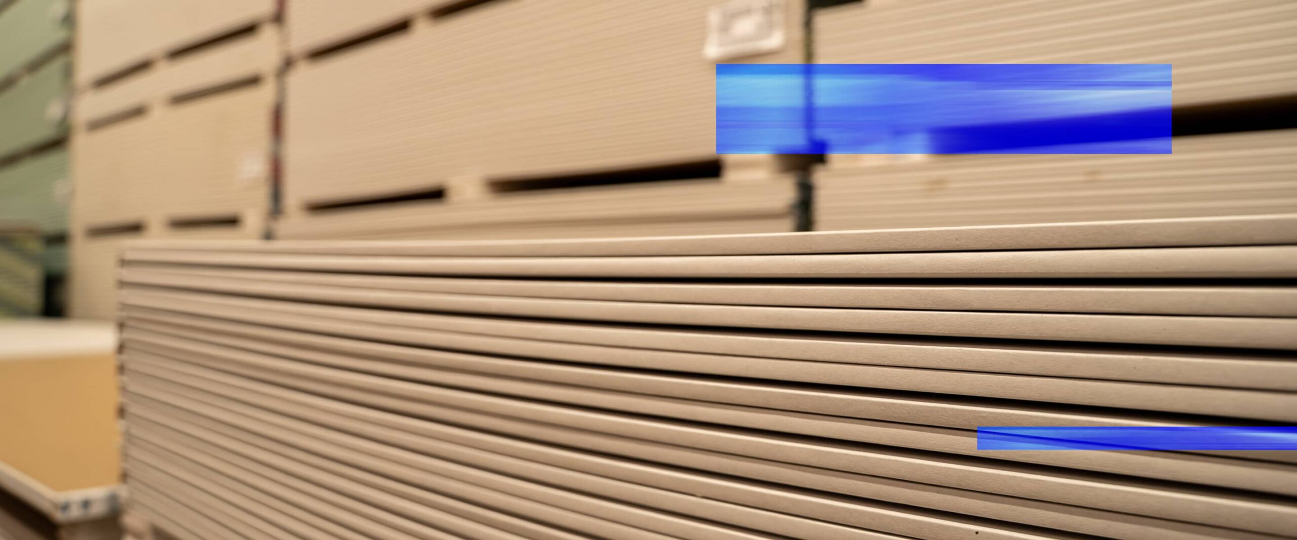 Warehouse aisle stocked with sheet goods and building materials.