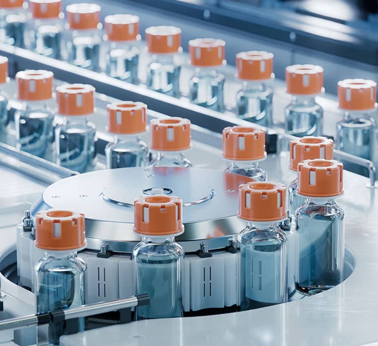 Pharmaceutical vials move through an automated production system, demonstrating automation solutions for the pharmaceutical industry.