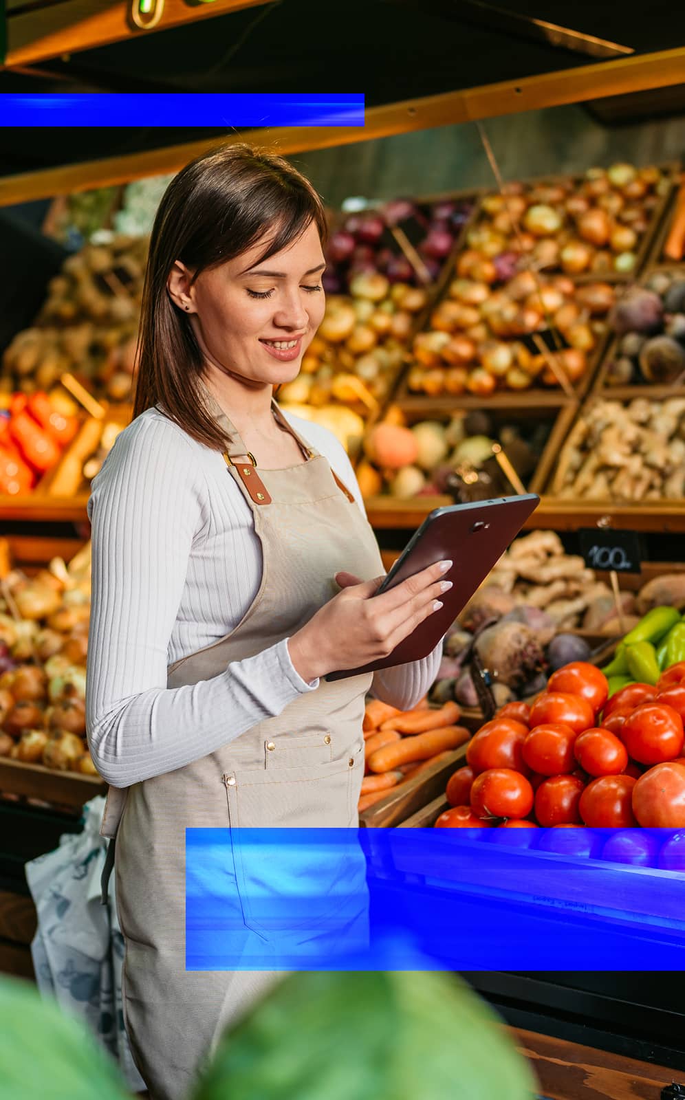 Retail employee using a tablet in a grocery produce department to support inventory.