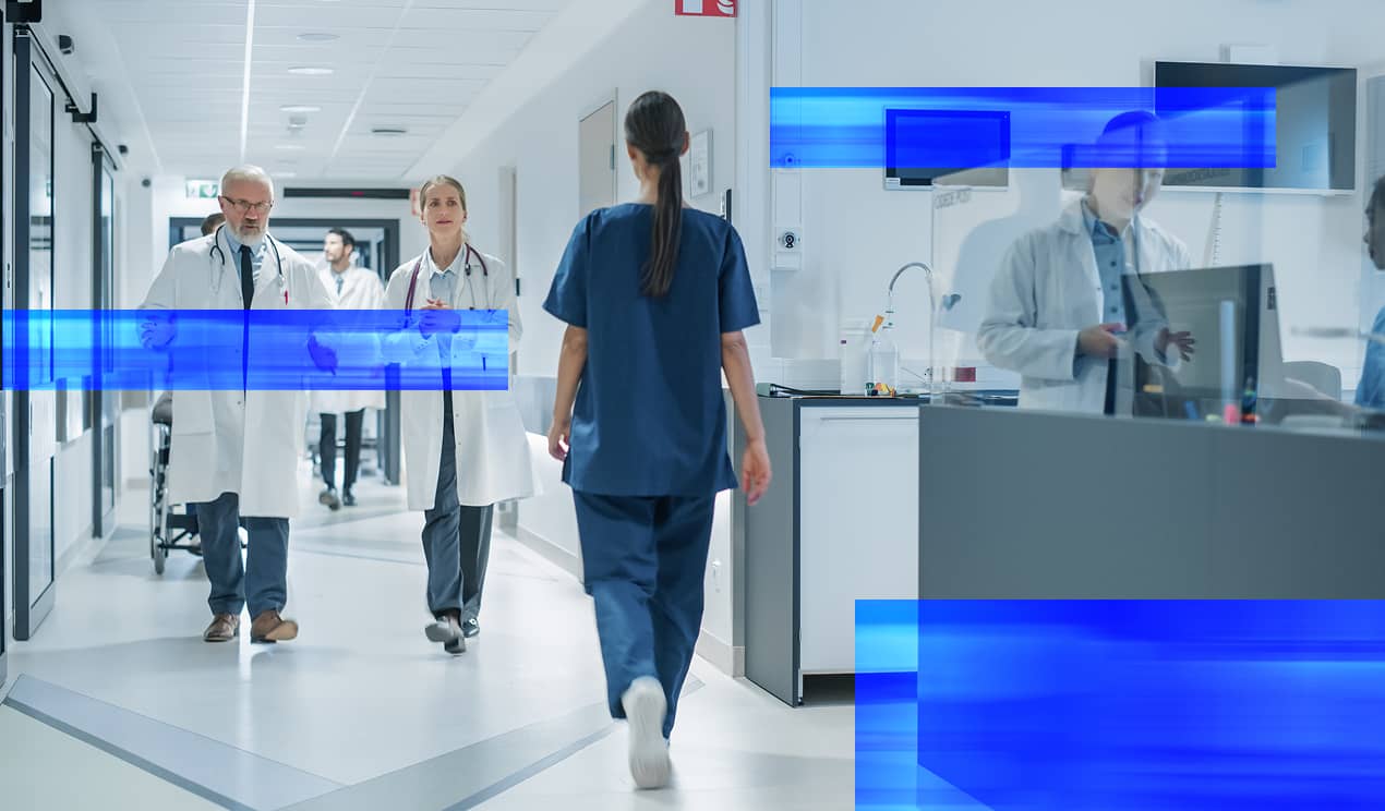Le personnel hospitalier se déplace dans un couloir très fréquenté de l'établissement.