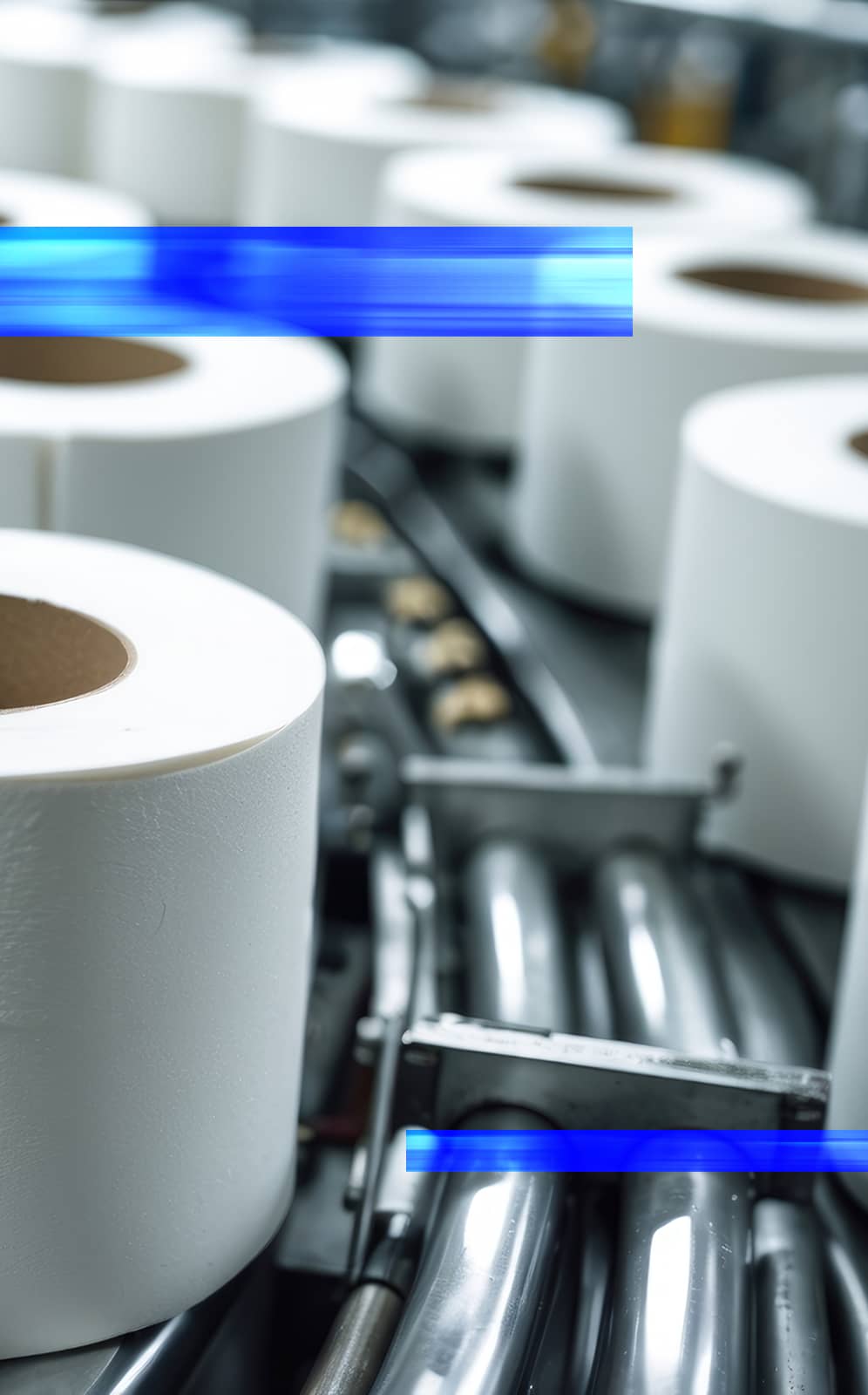 Large rolls of tissue paper in a production facility, representing automation solutions for packaging companies