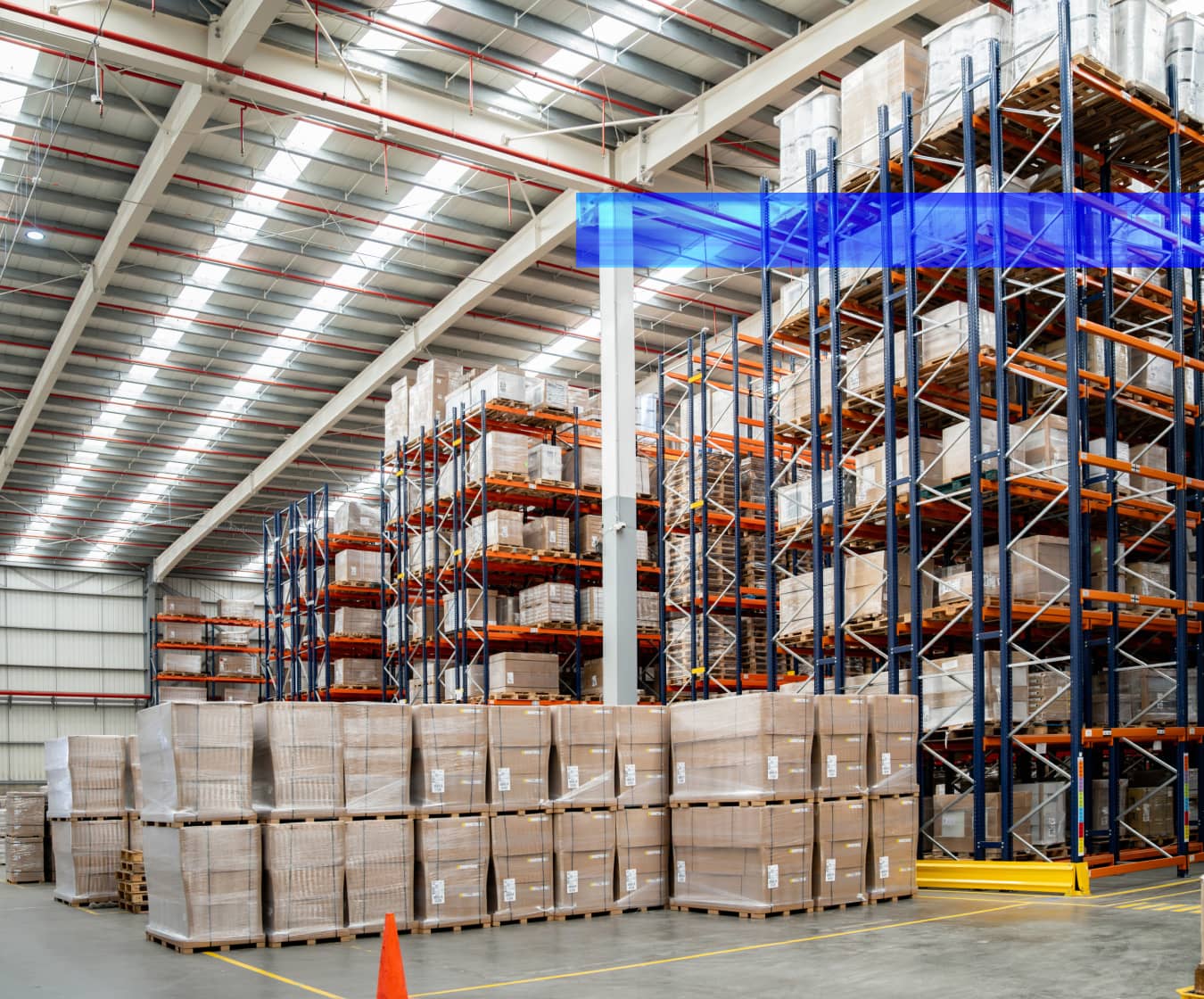 Rows of pallet racks filled with inventory extend through a warehouse.