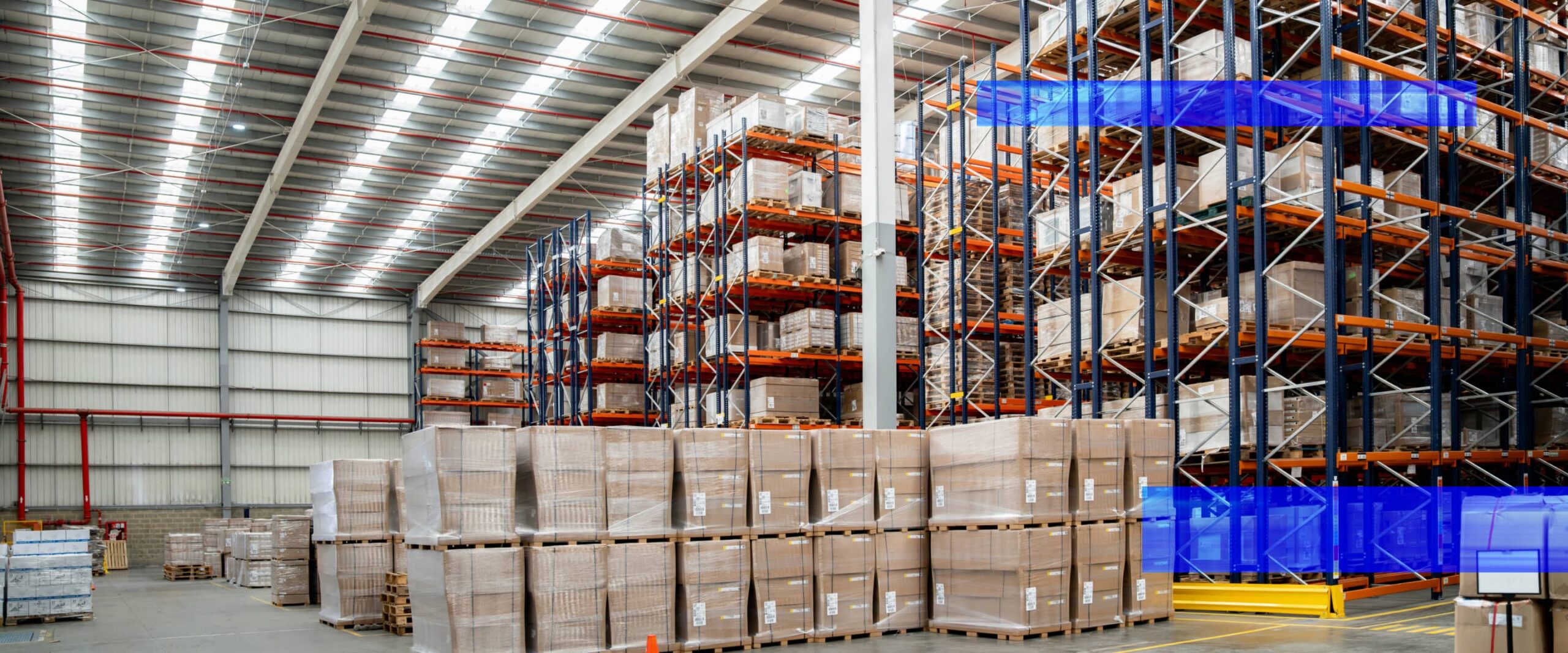 A warehouse interior with high-bay storage racks and palletized inventory.